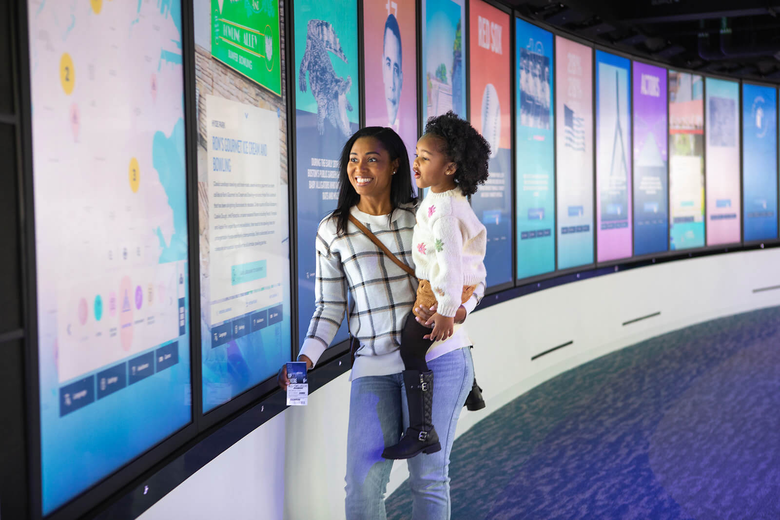 A mother and child exploring interactive displays at View Boston