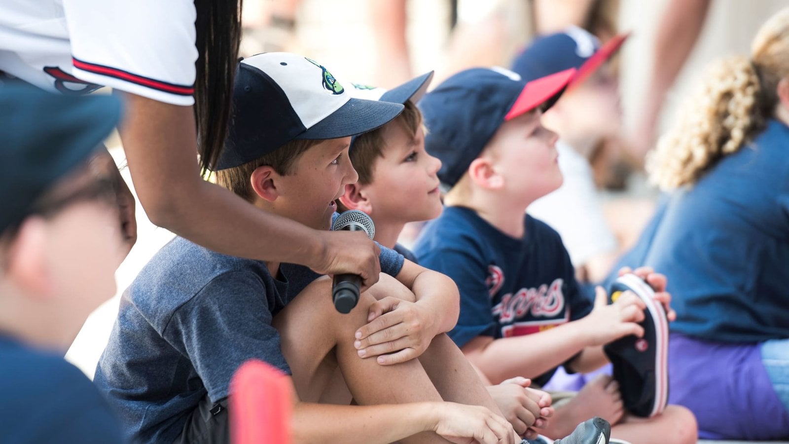 Children answering a microphone at a Braves event
