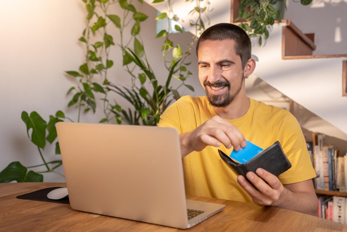 Hombre con portátil y cartera revisando información financiera