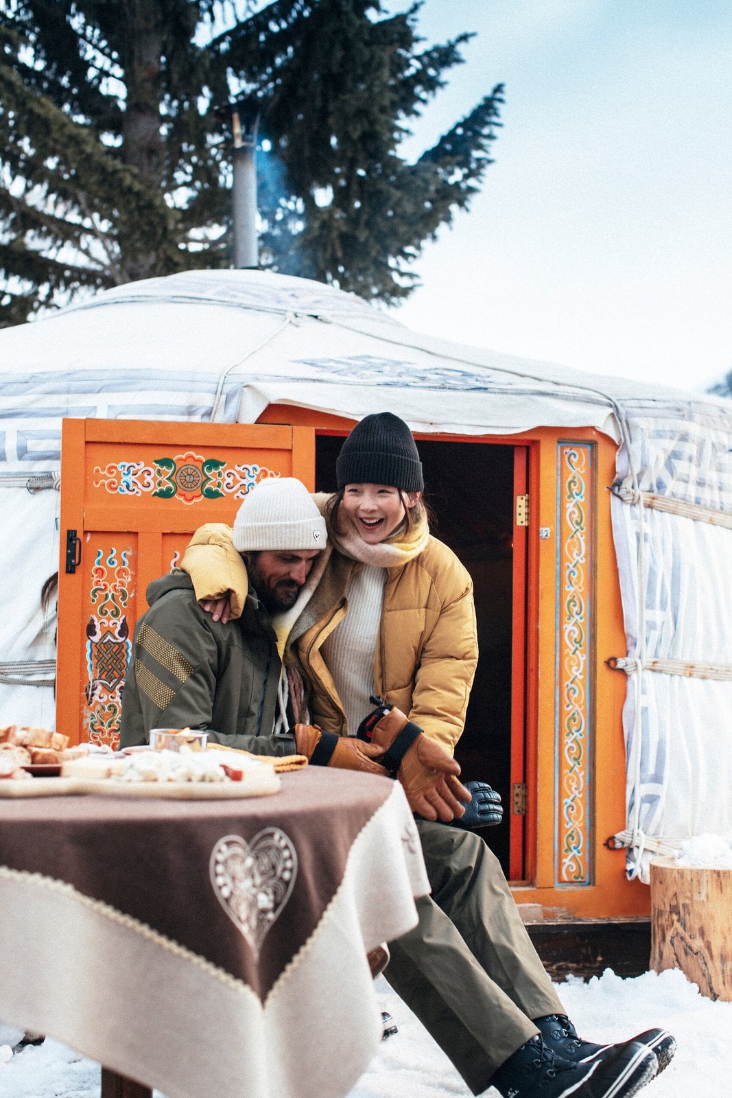 Two guests outside a decorated snow lodge