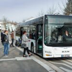 Menschen steigen in einen Bus ein