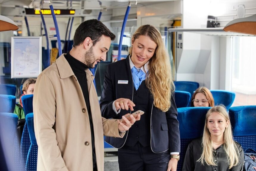 Schaffnerin prüft das digitale Ticket eines Fahrgasts im Regionalzug