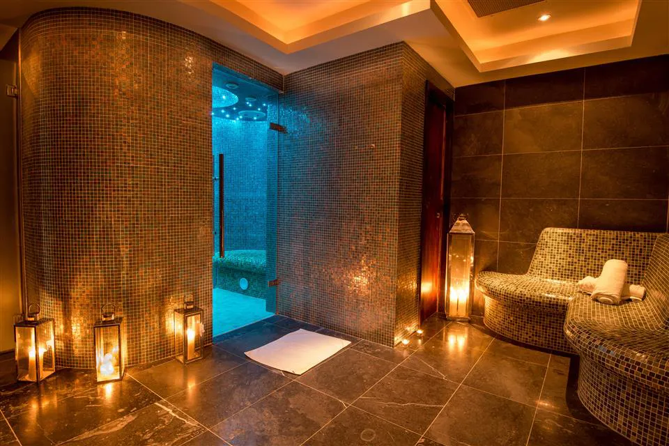 Warmly lit indoor hotel spa with a pool
