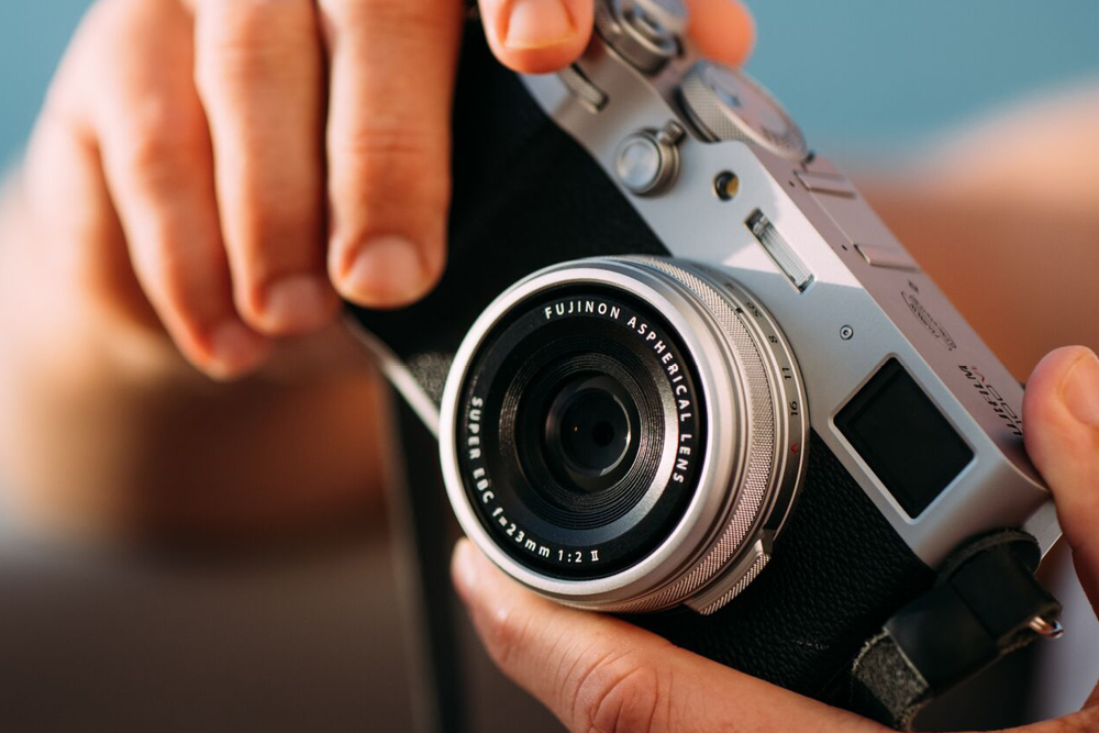 Hände halten eine Fujifilm-Kompaktkamera aus dem Grover-Sortiment