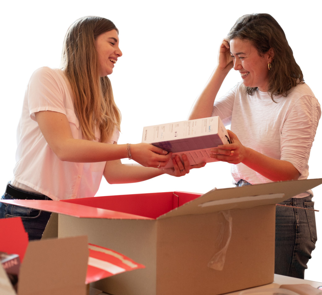 Zwei Frauen packen ein geliefertes Mietgerät aus einem Grover-Karton aus