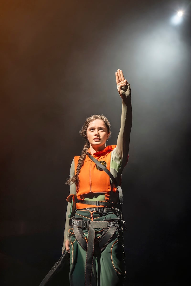 A performer playing Katniss during the stage production