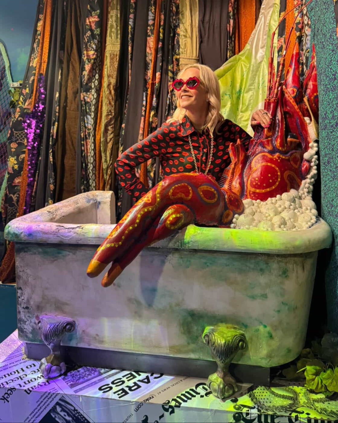 Guest sitting in the crawfish boil bathtub exhibit at JAMNOLA