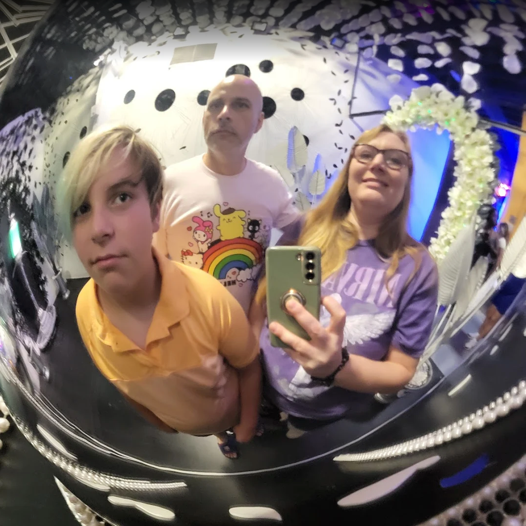 Three people taking a selfie in a reflective JAMNOLA installation