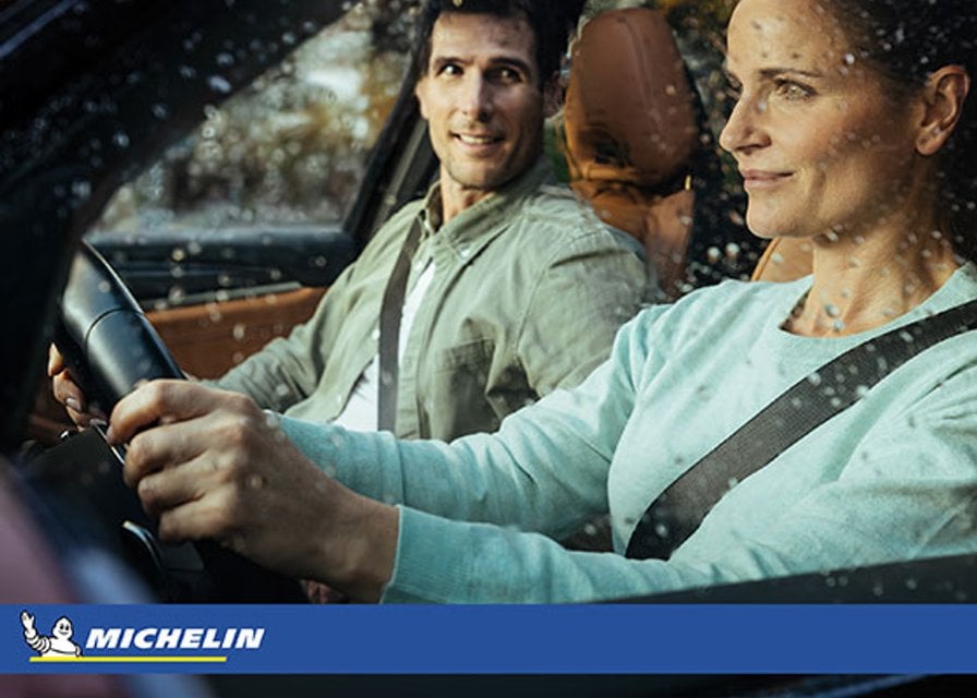 Paar fährt bei Regen mit einem Auto