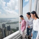 Family looking out over the city from One World Observatory
