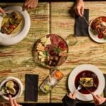 Goście przy wspólnym stole podczas kolacji w restauracji