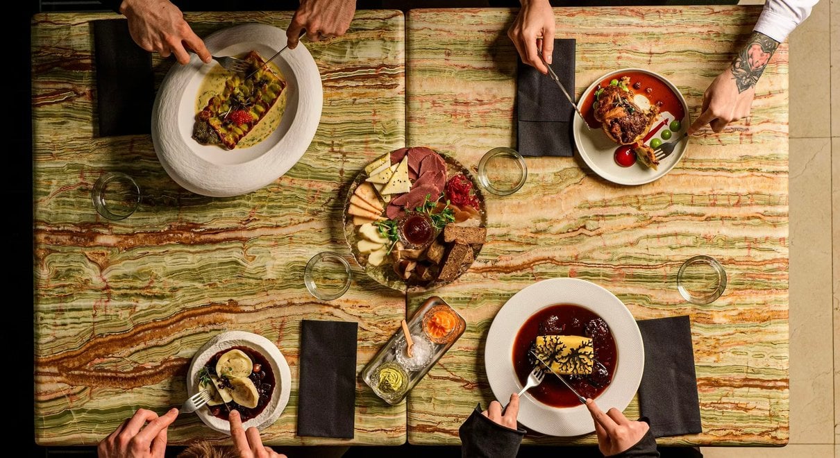 Goście przy wspólnym stole podczas kolacji w restauracji