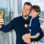 A father and child taking a selfie with the London skyline from The Shard