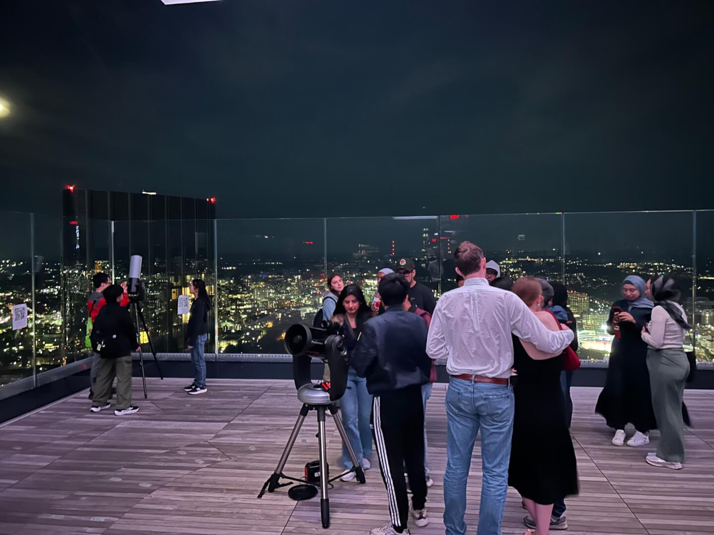 Visitors using telescopes on the View Boston rooftop