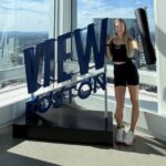 Woman standing beside the View Boston sign