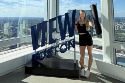 Woman standing beside the View Boston sign