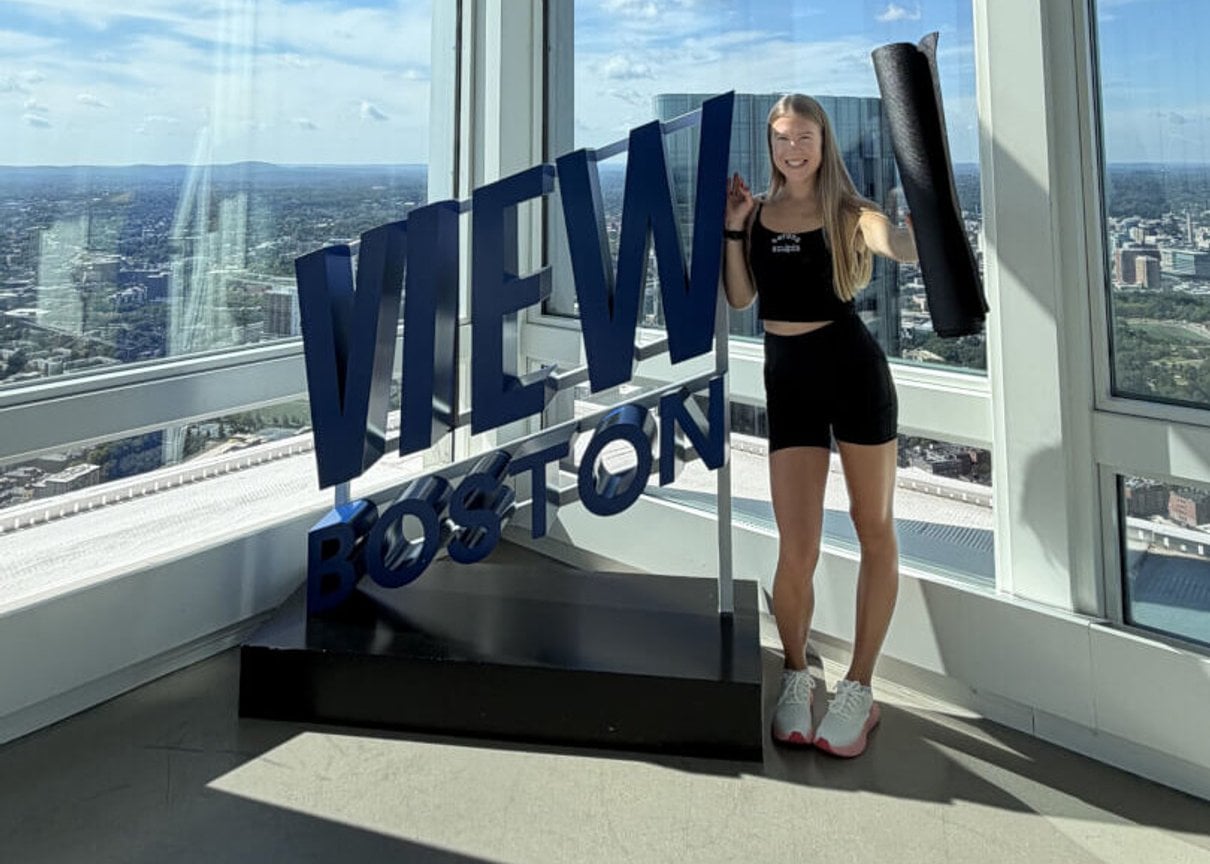 Woman standing beside the View Boston sign
