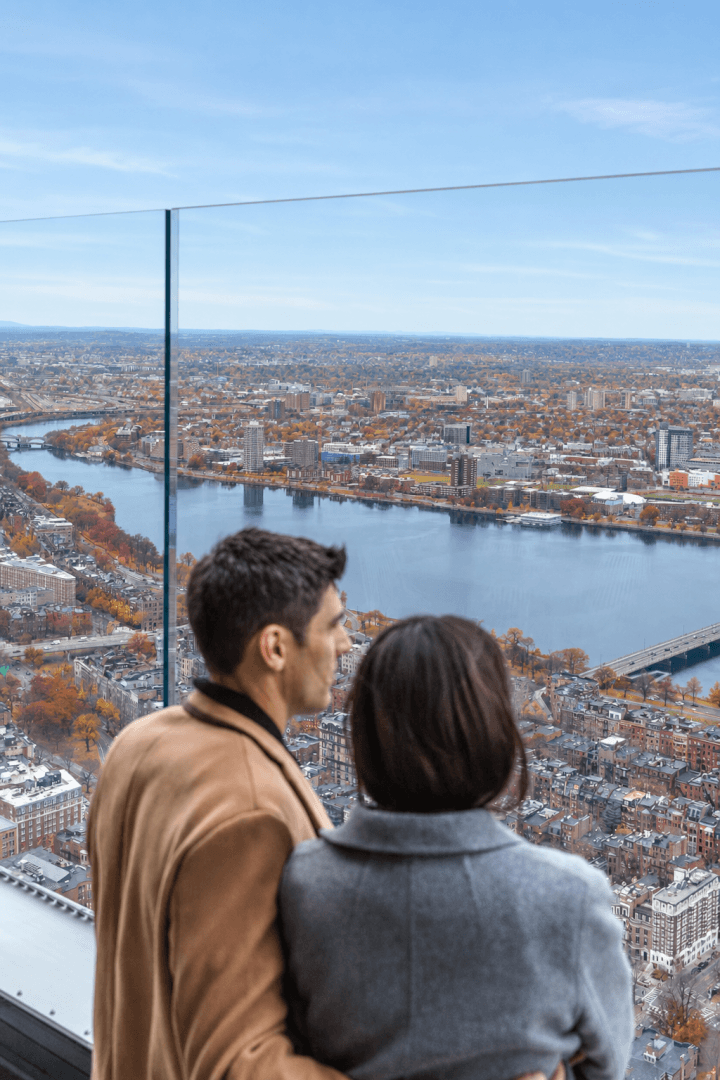 Two visitors looking out over the city at View Boston